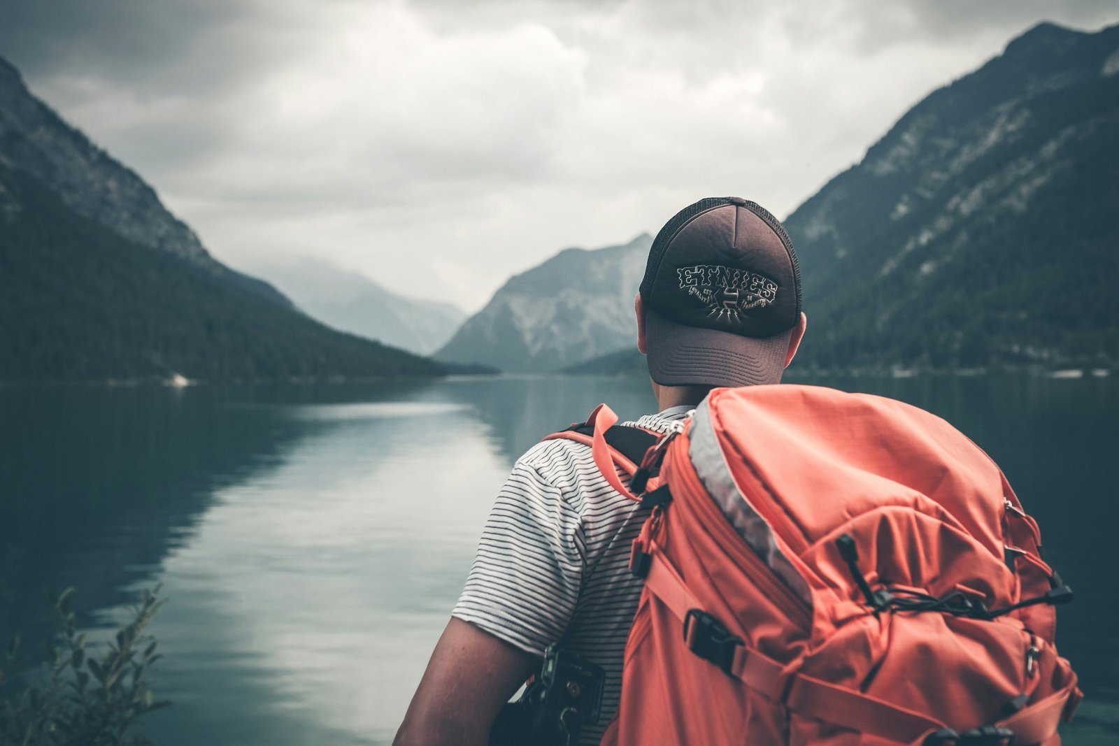 A solo traveler staring at a lake.