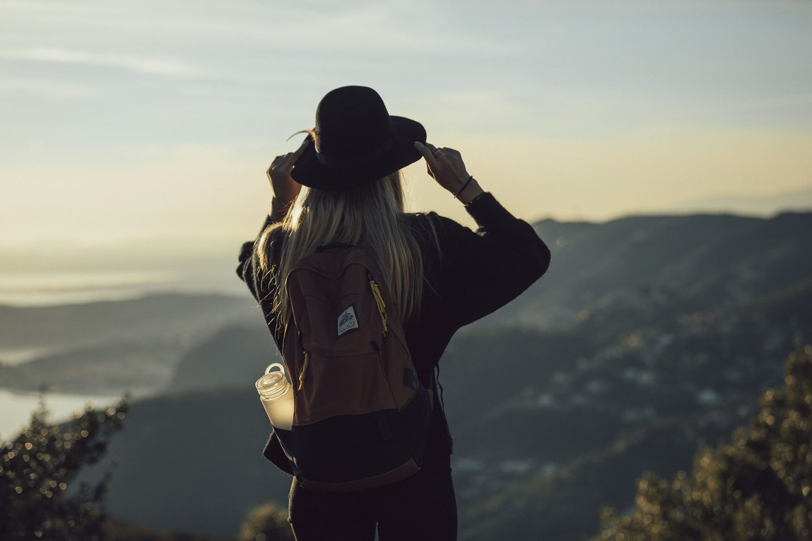 Explore the solo travel safety tips for women in their 30s. Featured is a solo traveler on top of a mountain.