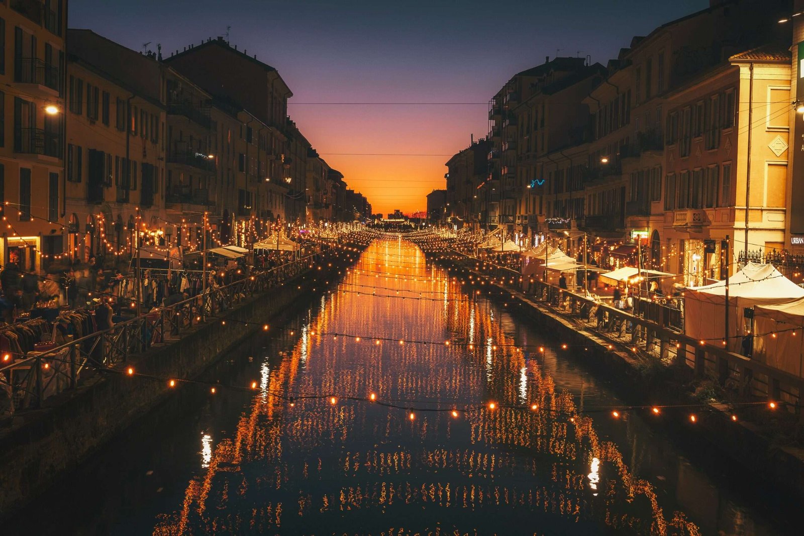 Discover the best things to do in Milan. Featured is a lit up canal at night.