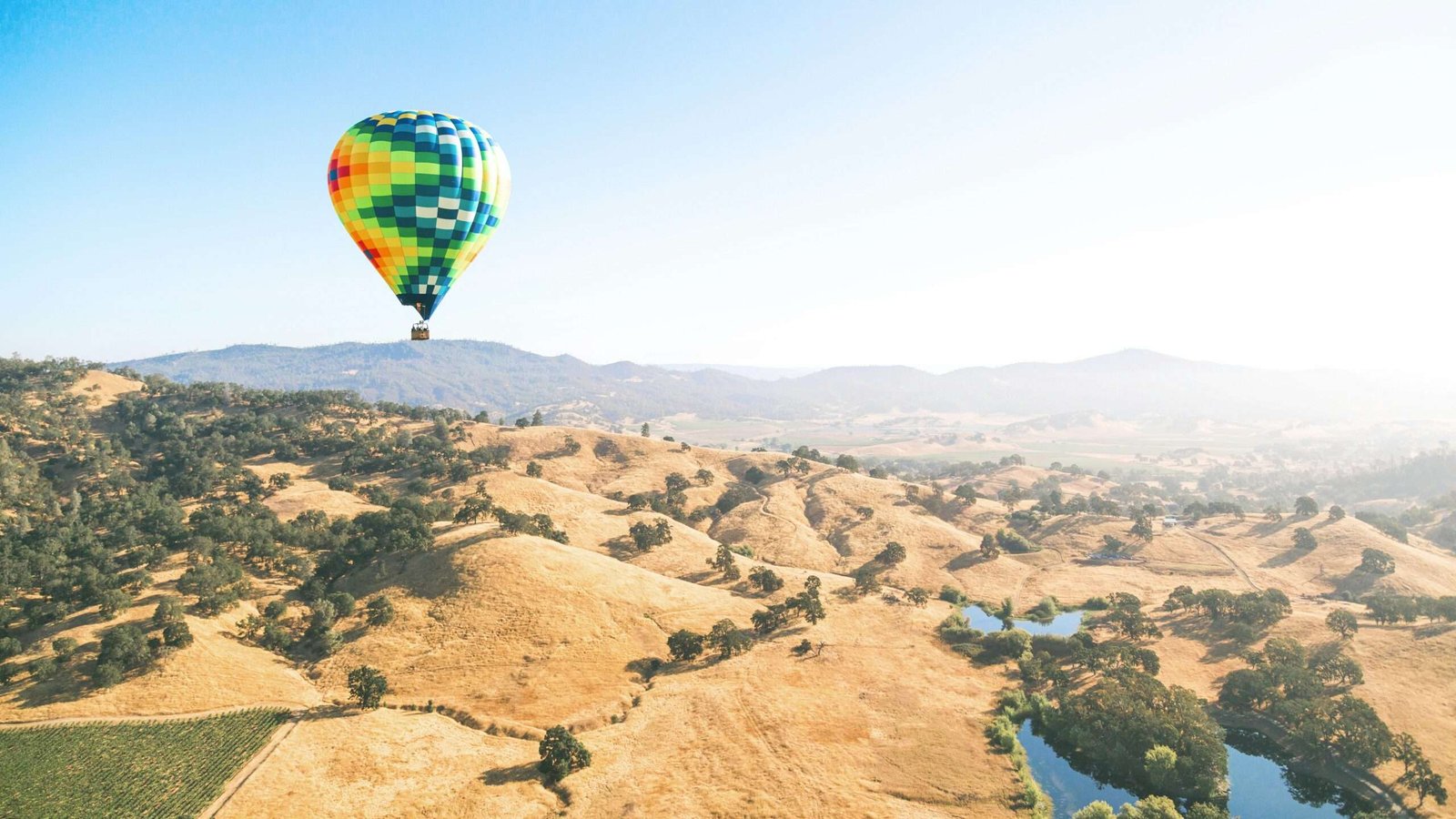 Napa Valley is one of the best places for a bachelorette party. Featured is an aerial view of Napa Valley with a hot air ballon in the shot.